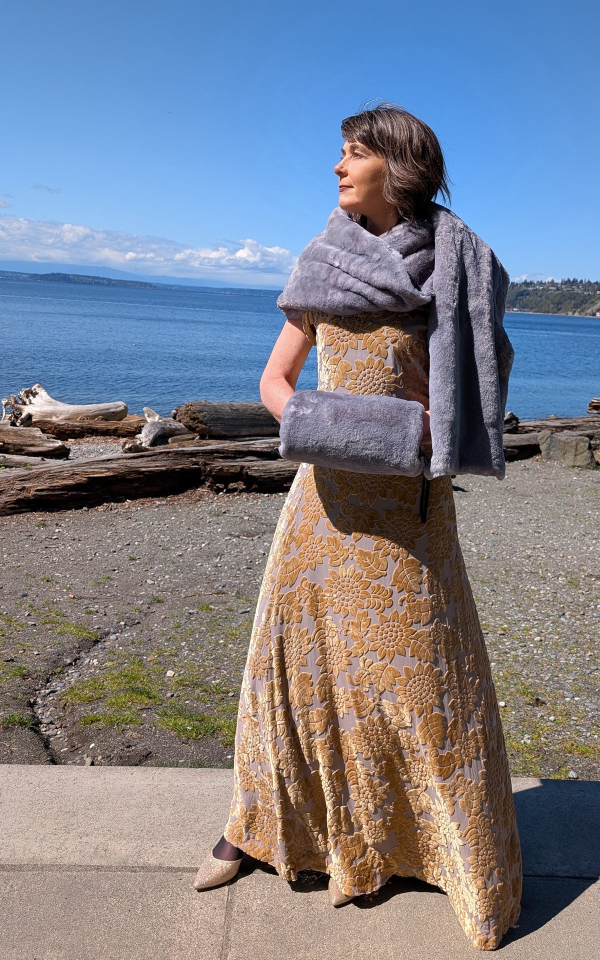 Woman standing by the water in gown wearing the Stole in Olympic Fog Faux Fur with matching hand Muff.  Handmade in Seattle, WA, USA