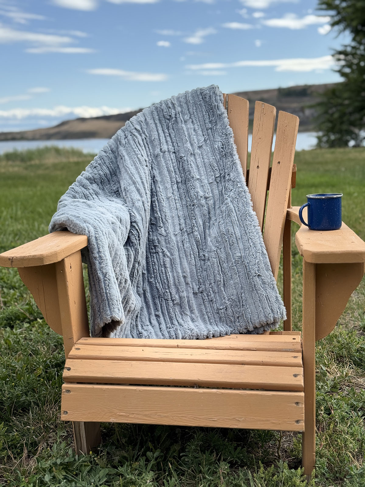 Cirrus in Blue Mist Standard Throw over a chair by a lake. Hand sewn in Seattle, Washington by Pandemonium Seattle.