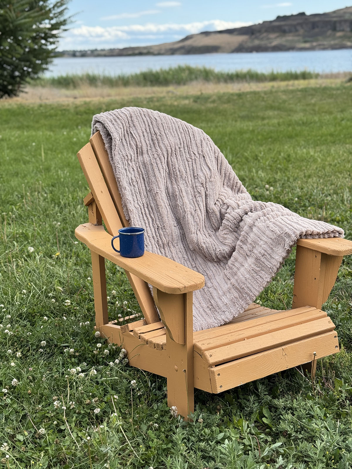 Cirrus in Honey Standard Throw over a chair by a lake. Hand sewn in Seattle, Washington by Pandemonium Seattle.