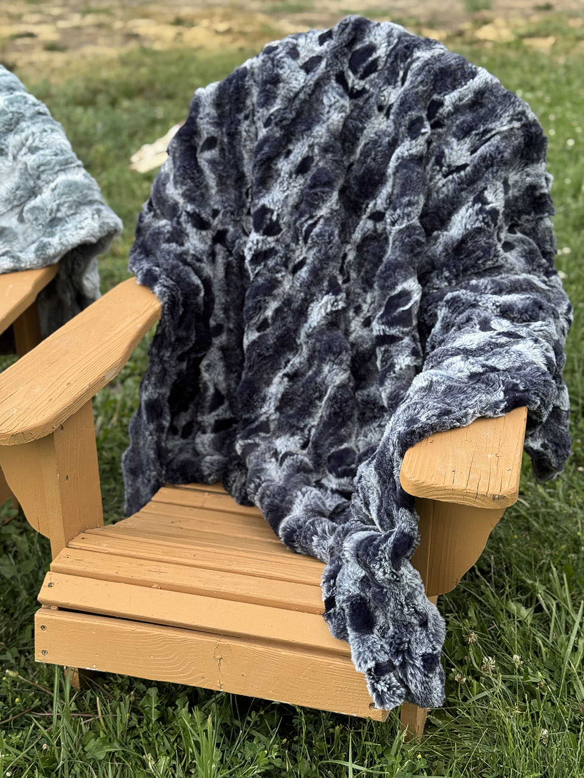 Throw blanket in Cloudwalk Shadow, draped over a chair. Made in Seattle, WA, USA by Pandemonium Seattle.