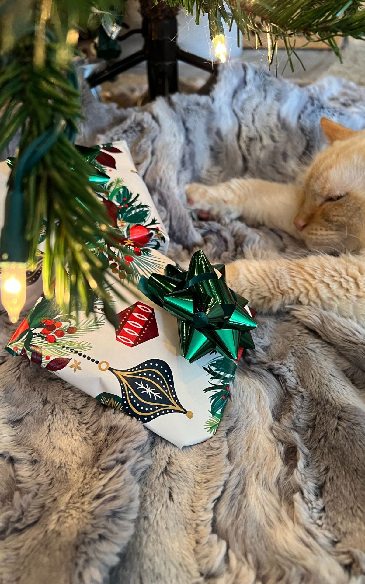 Cat laying under Christmas tree on tree skirt by a present  | Luxury Faux Fur Designer | Handmade by Pandemonium Millinery Seattle, WA usa