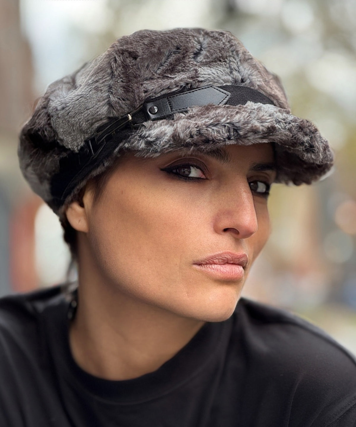 Woman wearing the Valerie Cap in Rock Steady Faux Fur with a black band and buckle. Made in Seattle, WA, USA by Pandemonium Seattle.