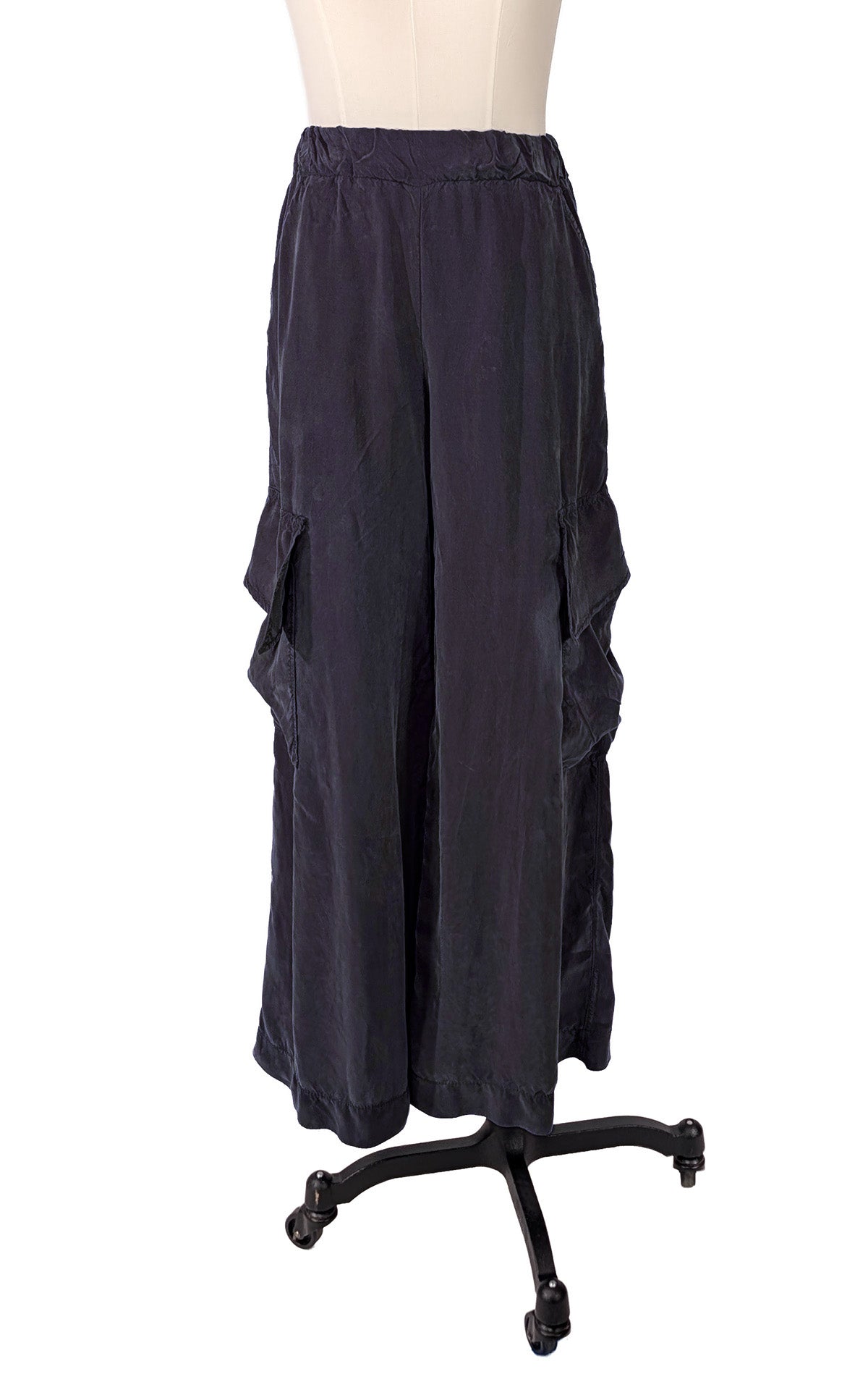 A pair of dark navy wide-leg cargo pants displayed on a mannequin torso with a black rolling stand against a plain white background. Made in Seattle, WA, USA by Pandemonium Millinery.