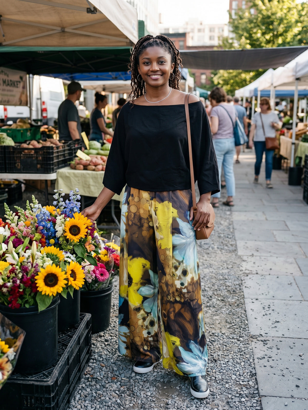 A woman wearing the Wide Leg Pleated Pants in Fiesta Silk Masquerade with the Off the Shoulder Top in Obsidian Cupro fabric. Made in Seattle, WA, USA by Pandemonium Seattle.