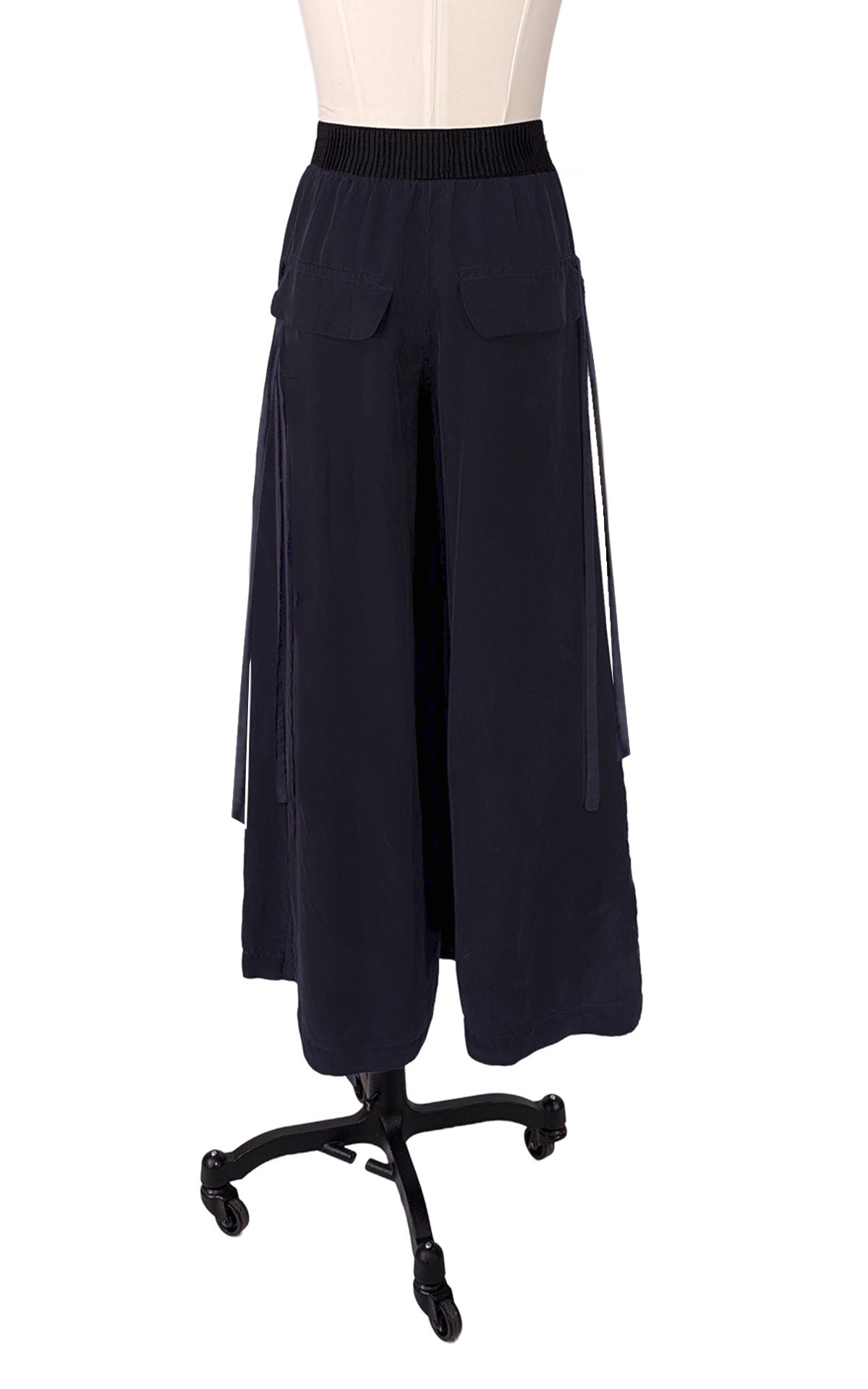 A pair of wide-leg, high-waisted navy blue pants displayed on a mannequin torso with a black rolling stand against a plain white background.