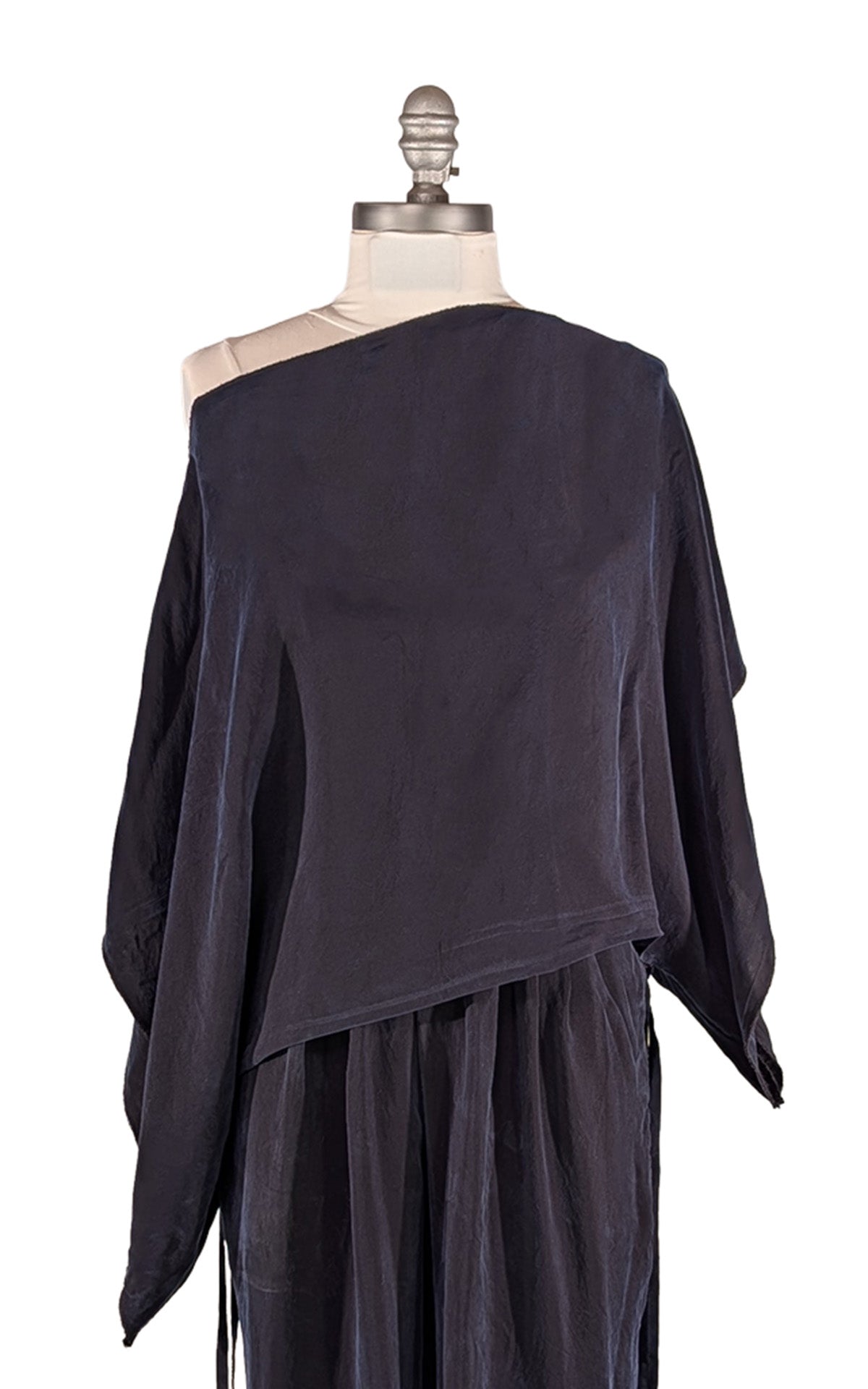 A navy draped, asymmetrical Off the Shoulder Top displayed on a mannequin torso against a plain white background. Made in Seattle, WA, USA by Pandemonium Seattle.