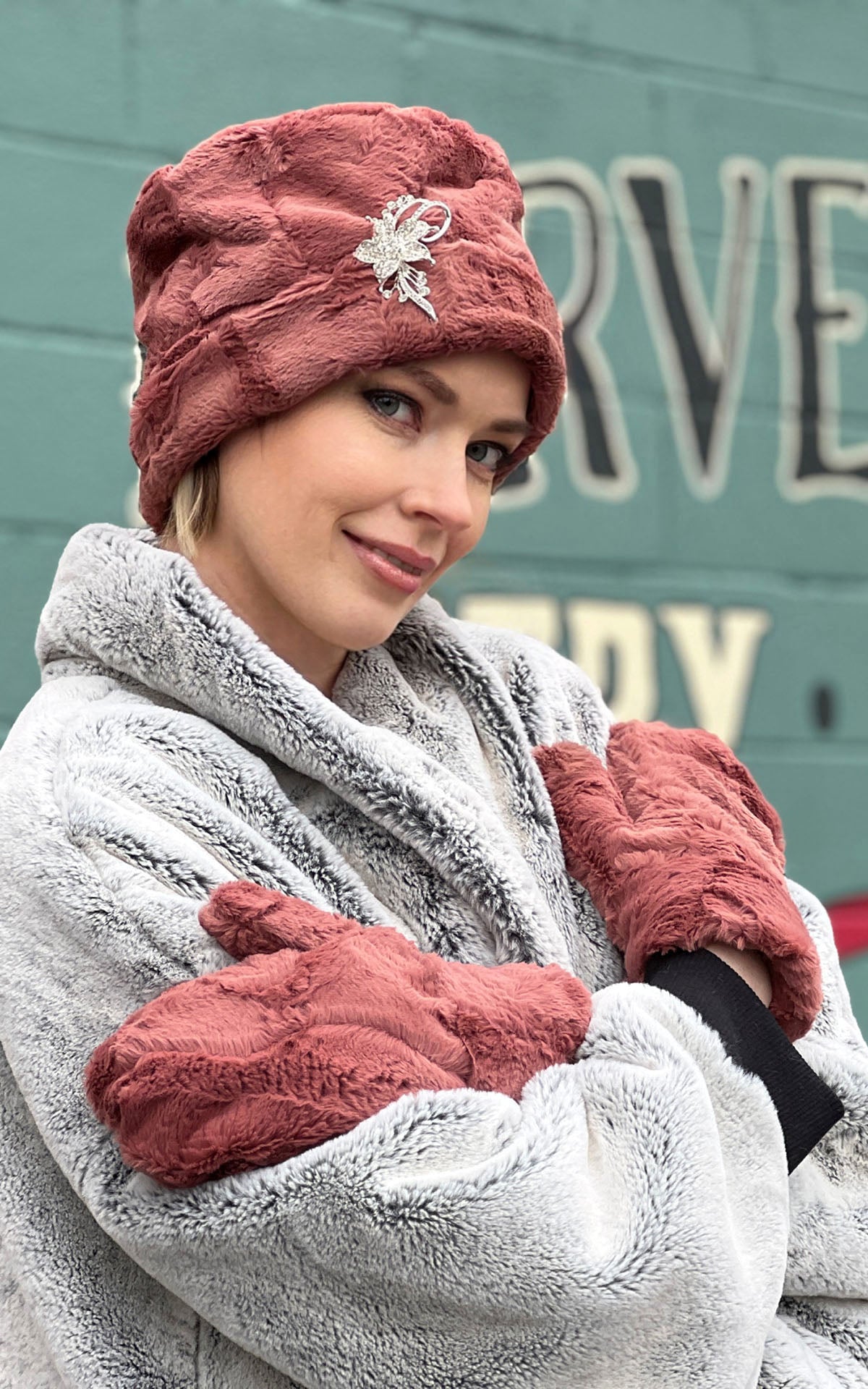 Model wearing Cuffed Pillbox in Copper River faux fur  with matching mittensby Pandemonium Millinery handmade in Seattle WA