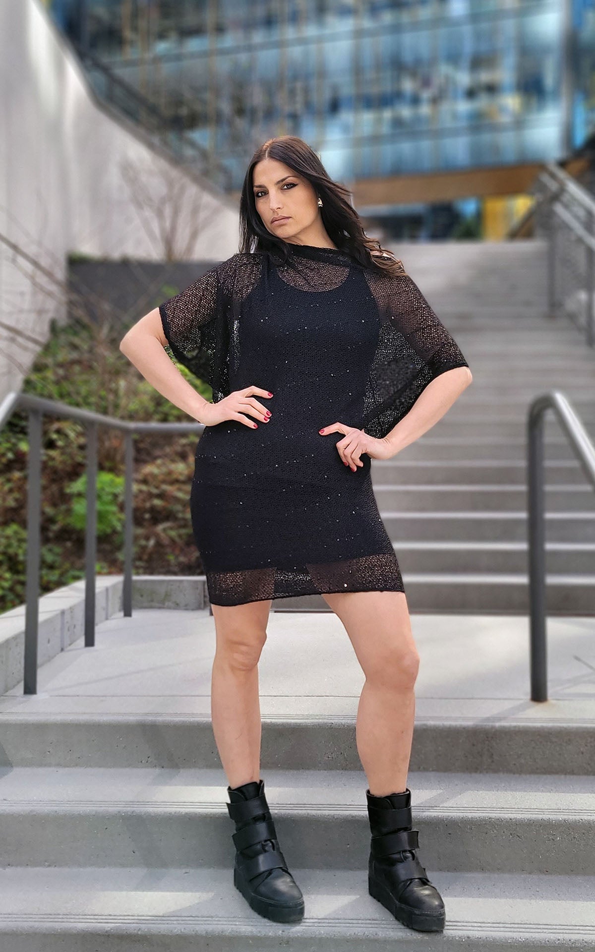 woman standing on stairs wearing a sheer black sequin dress handmade in America by Leigh Young Collection