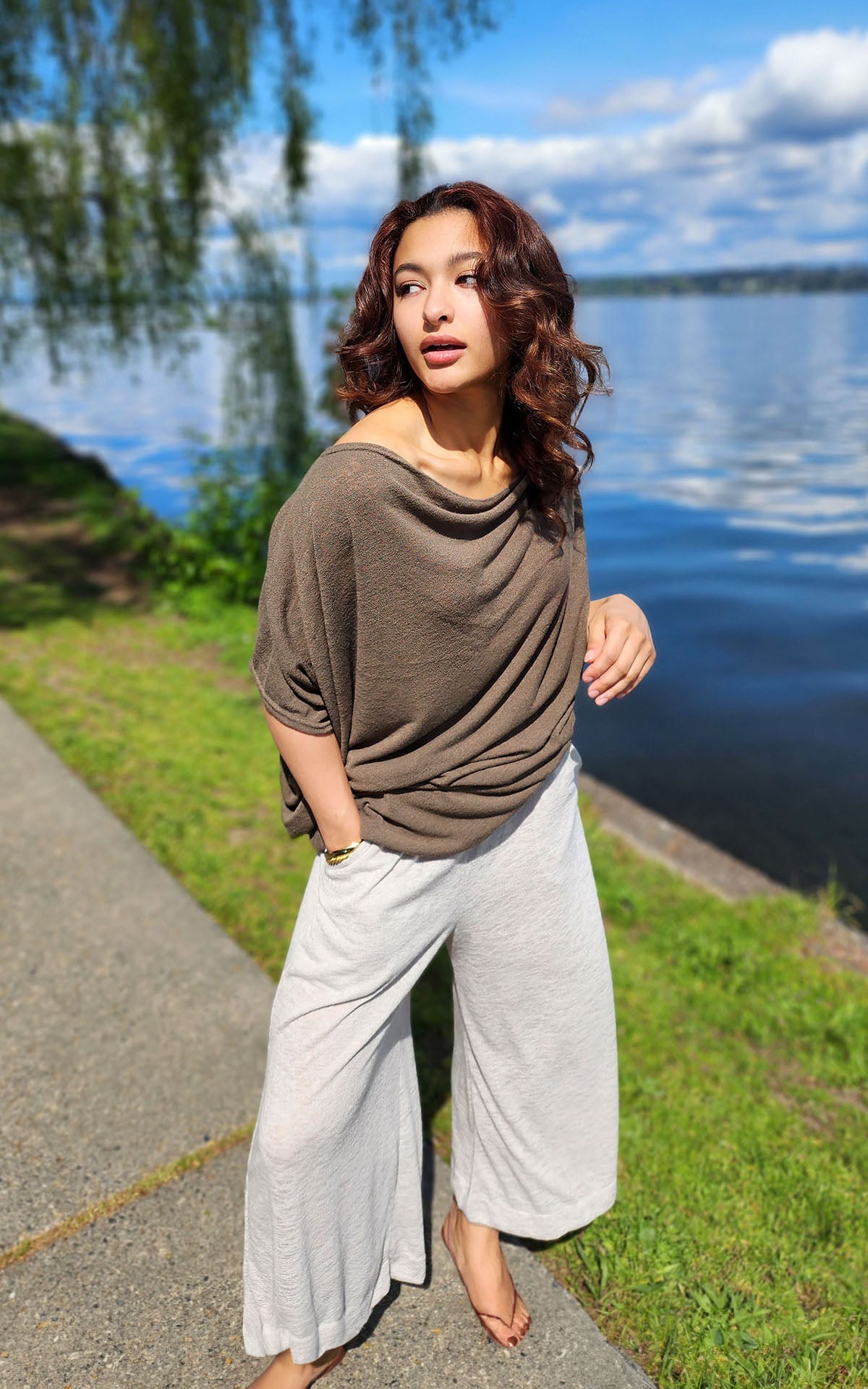 Model wearing South West Gaucho Pants in Crepe Sandstone with Mezcal Cocoon Top standing by water. Leigh Young Collection.