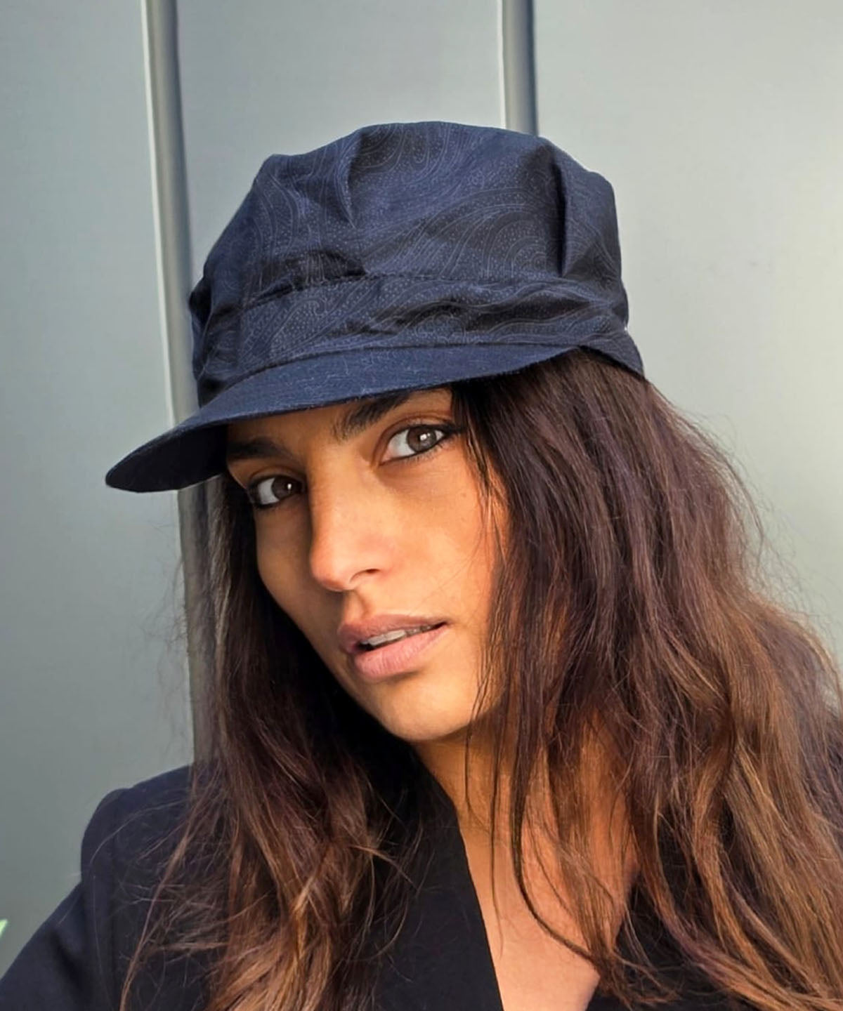 Woman wearing Cyndi Cap | Paprika Paper Flowers Cotton Print | Handmade in USA by Pandemonium Millinery