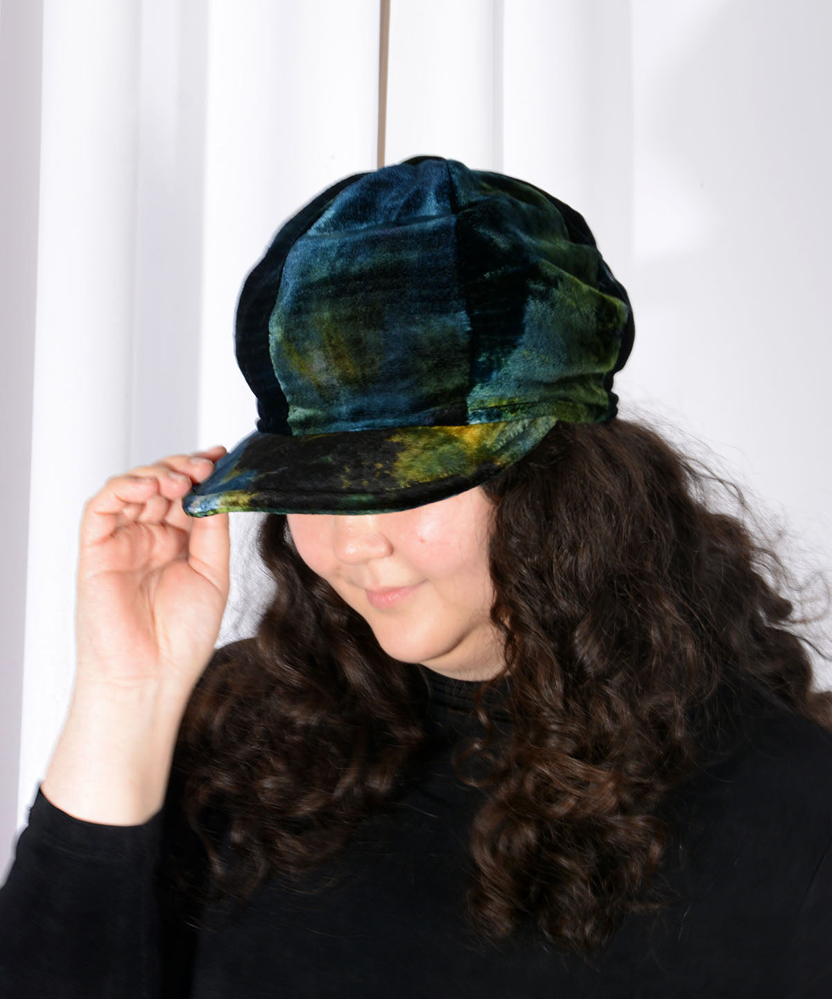 Model tippping brim down of Dianne Apple Style Cap in Velvet in Forest Floor Tie Dye | Handmade by Pandemonium Millinery | Seattle WA USA