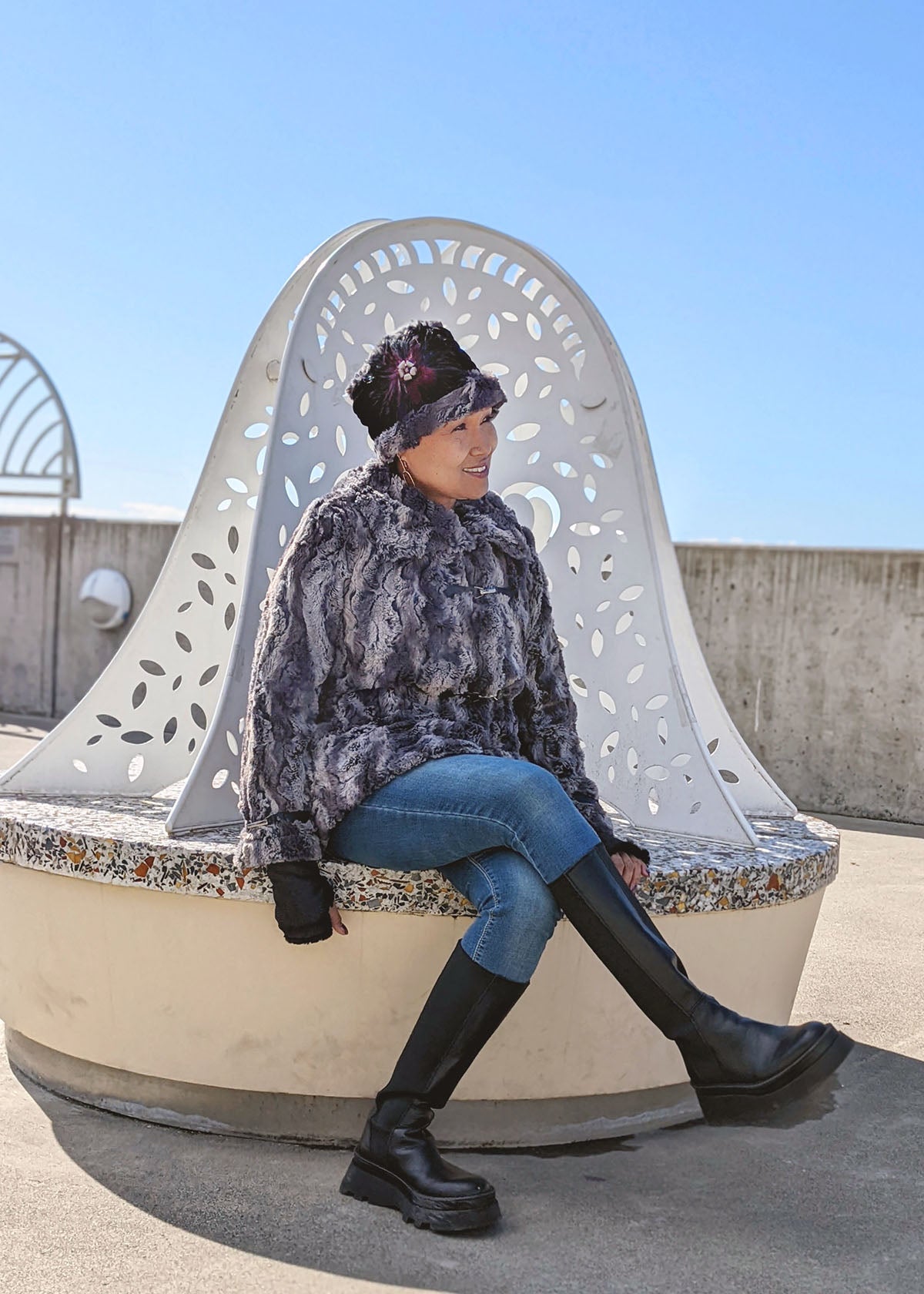 Model sitting in chair wearing a Dietrich Coat in Muddy Waters.  Handmade in America by Pandemonium Seattle.