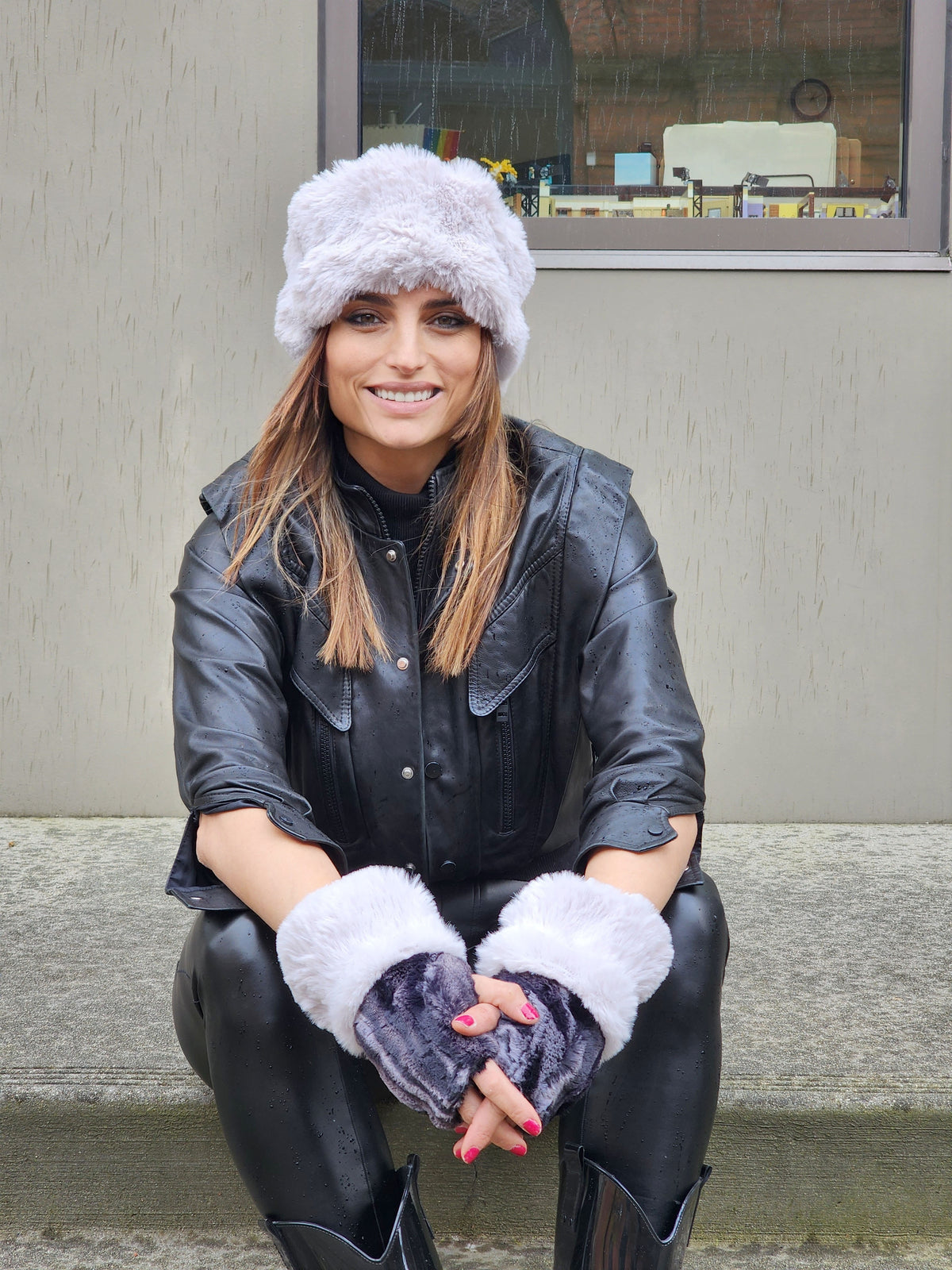 Model on steps wearing Cuffed and Ear neck Cozy Fingerless Gloves or Hand Warmers in Marble in Black Dune with Fairy Dust Cuffs. The Enchanted Dreams Faux Fur gloves are handmade in Seattle, WA, USA by Pandemonium Seattle.