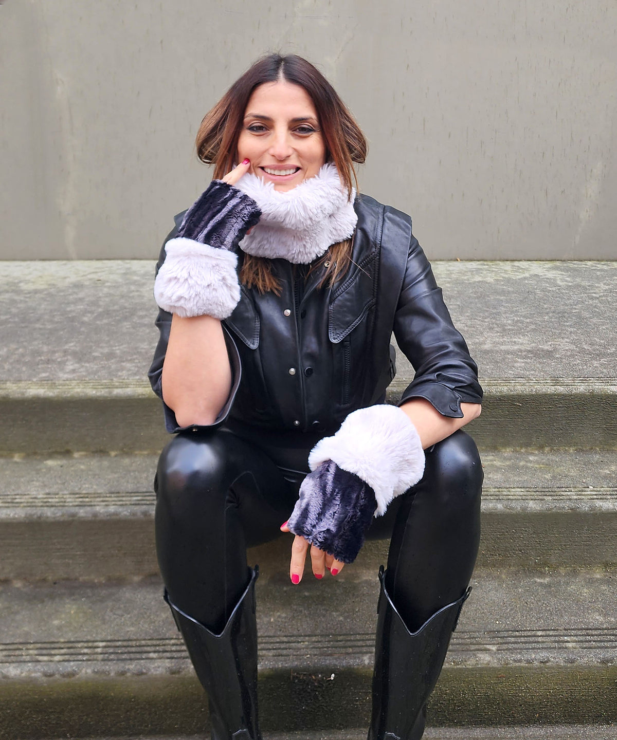 Model on steps wearing Cuffed and Ear neck Cozy Fingerless Gloves or Hand Warmers in Marble in Black Dune with Fairy Dust Cuffs. The Enchanted Dreams Faux Fur gloves are handmade in Seattle, WA, USA by Pandemonium Seattle.