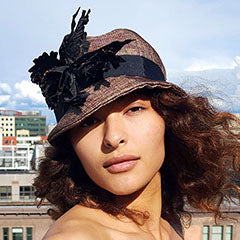model wearing cloche hat with large floral trim handmade by pandemonium millinery in seattle wa usa
