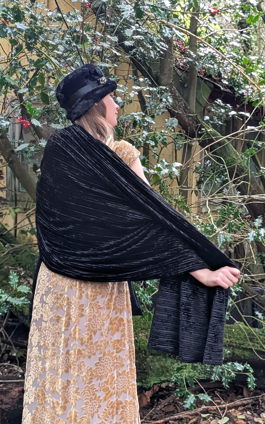 Back view of Woman wearing gold dress paired with an Evening Wrap in Night Owl Pleated Velvet handmade in USA by Pandemonium Seattle