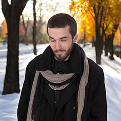 man in black peacoat standing in a snowy park wearing black and tan handkerchief scarf handkerchief scarf handmade in USA by Pandemonium Seattle