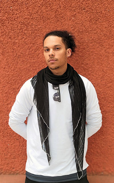 Man modeling Handkerchief Scarf in Voile Jet with White StitchingMan against rust wall wearing large Handkerchief scarf | Cotton Voile, Black with Contrast  White Stitching| Handmade in Seattle WA | Pandemonium Millinery