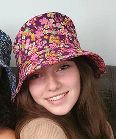 Head shot only of Model in Hollie Sun Hat in Purple Hana. Handmade in USA by Pandemonium Seattle.