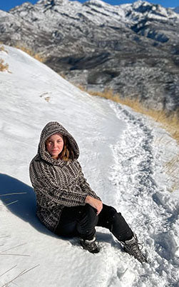 Woman Standing against brick wall wearing a Hooded Lounger | Luxury Faux Fur 8mm in Sepia |  Handmade by Pandemonium Millinery | Seattle WA USA