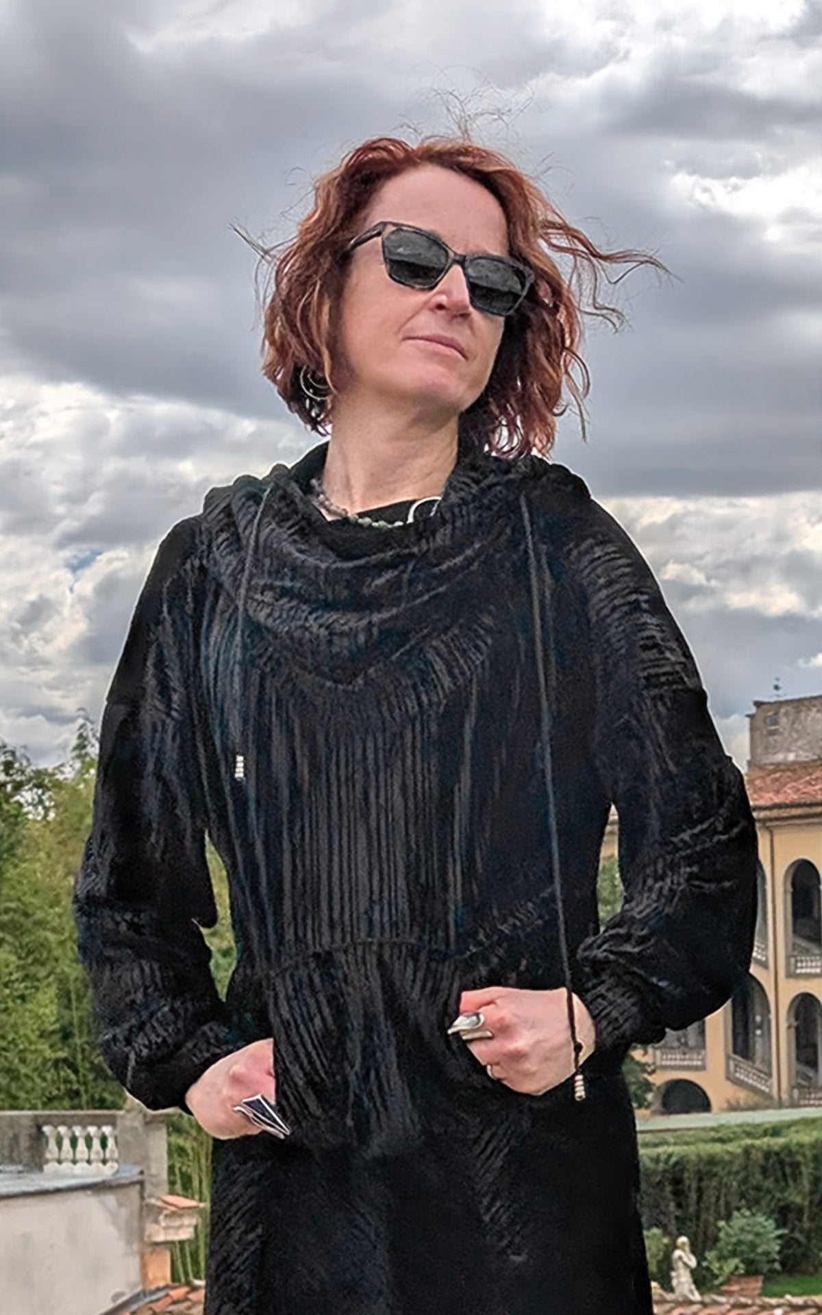 close up Woman wearing Slice of Life Hooded Sweatshirt in black Pleated Velvet with hood down and hands in pocket handmade in USA by Pandemonium Seattle