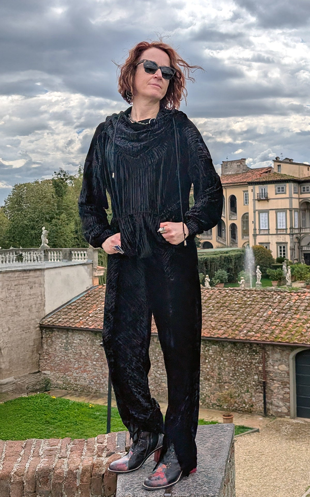 Woman wearing Slice of Life Hooded Sweatshirt in black Pleated Velvet with hood down and hands in pocket handmade in USA by Pandemonium Seattle