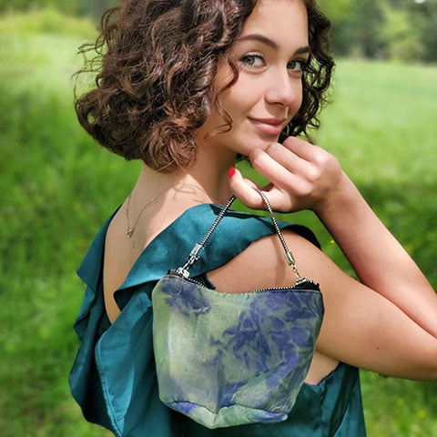 woman looking over shoulder holding small organdy purse handmade by Pandemonium Seattle USA