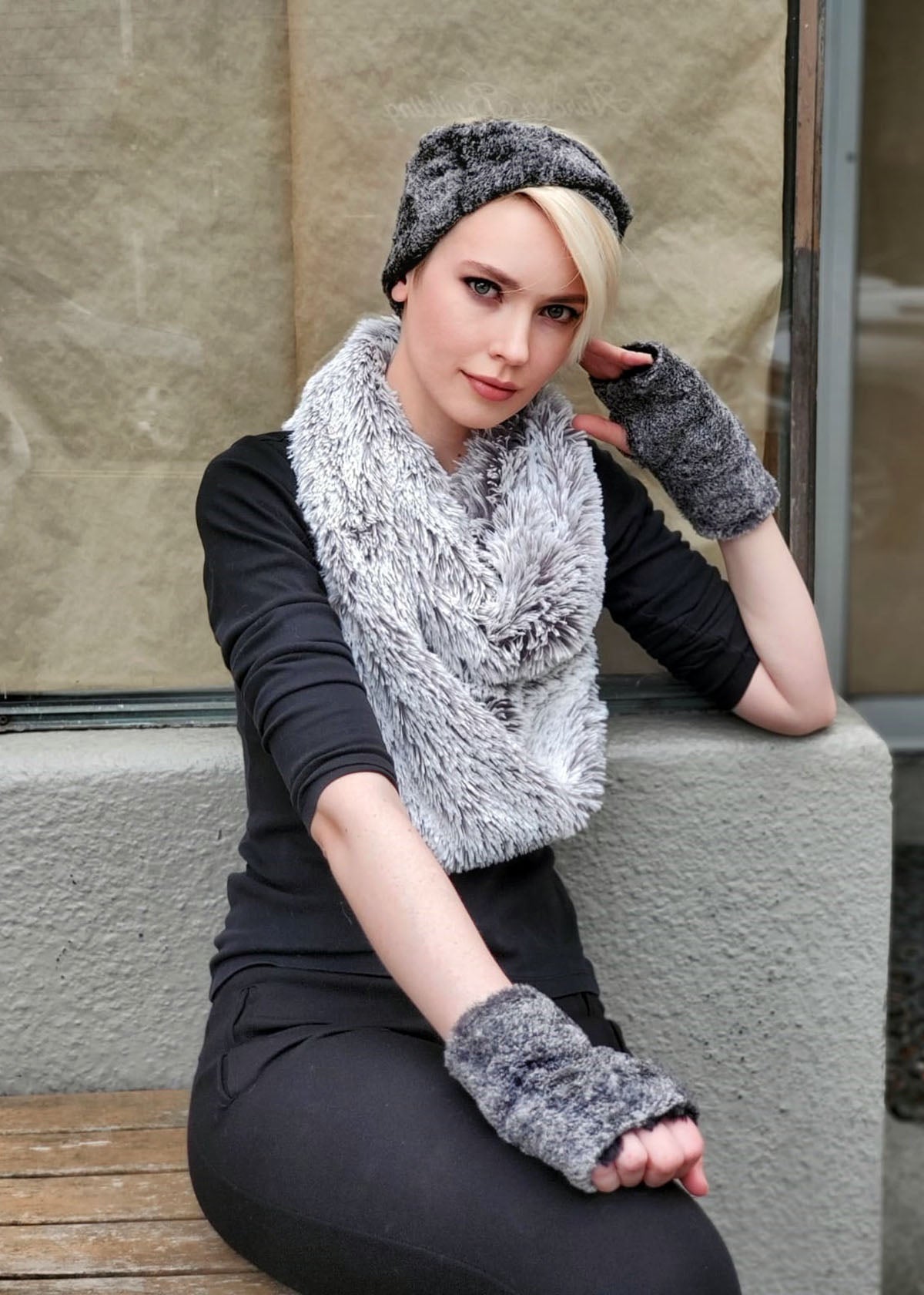 Model wearing of Headband and matching Fingerless Gloves and a Pearl Fox Infinity Scarf leaning against wall | Nimbus, Black and Gray Faux Fur | Handmade by Pandemonium Millinery Seattle, WA USA