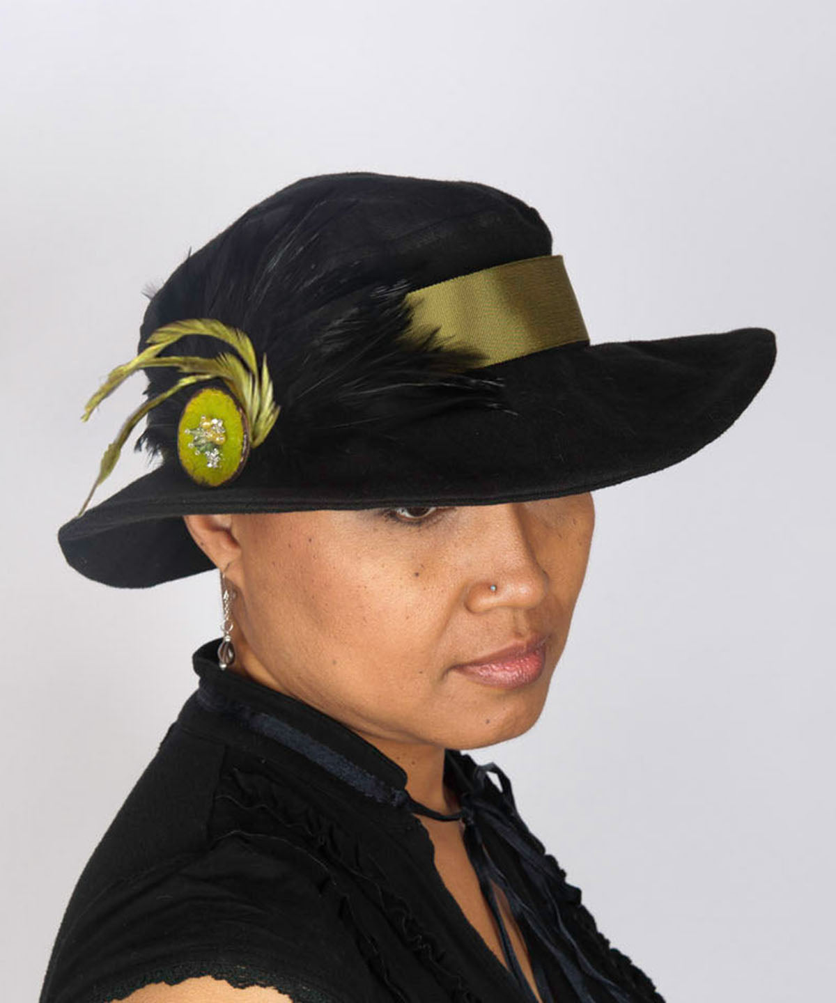Woman wearing Katherine Wide Brim Hat | Black Linen with Green Feather Brooch | Handmade USA by Pandemonium Seattle