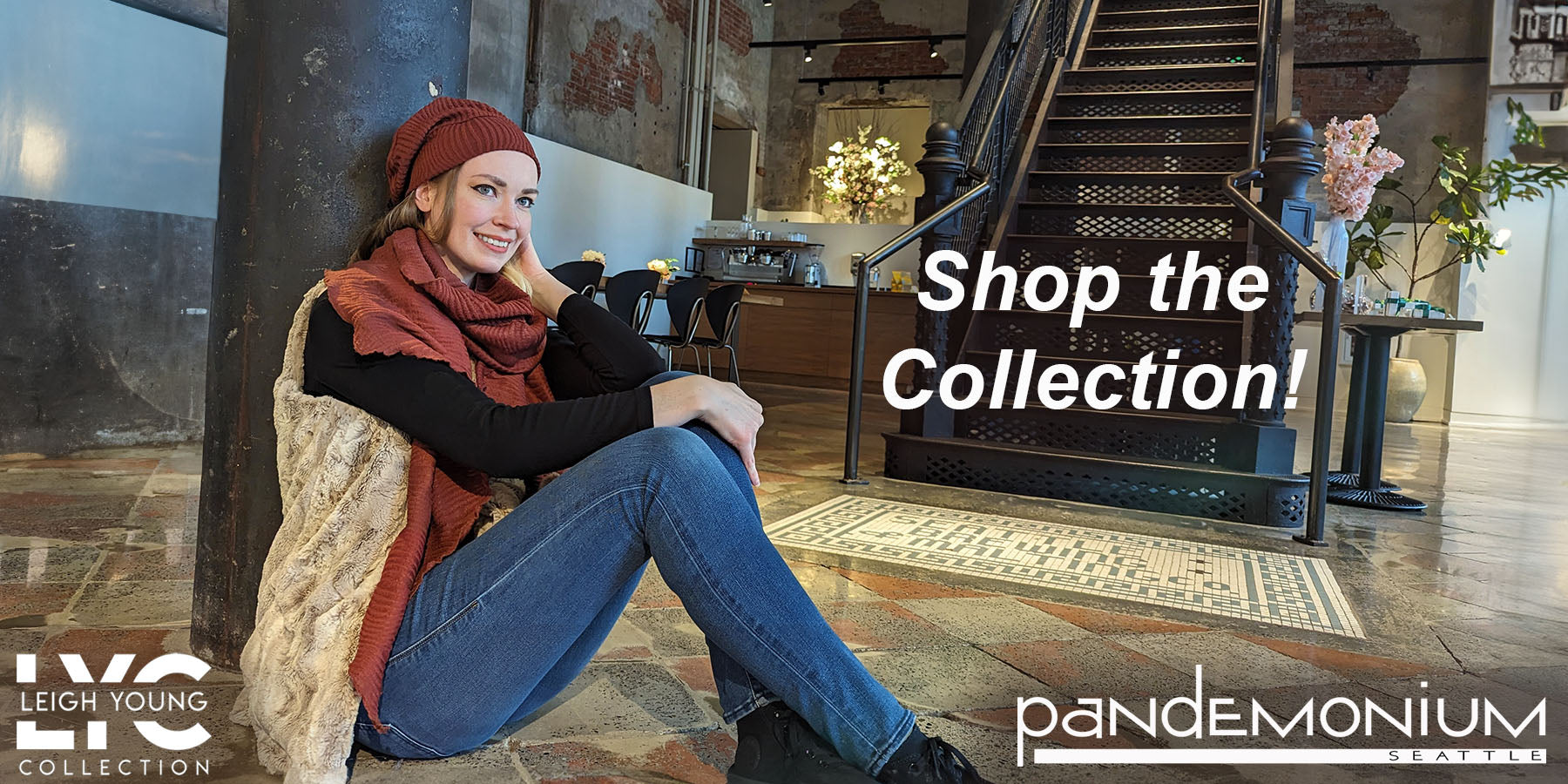 woman in rust scarf and hat with a cream faux fur vest sitting on tiled floor for Pandemonium Seattle desktop banner image