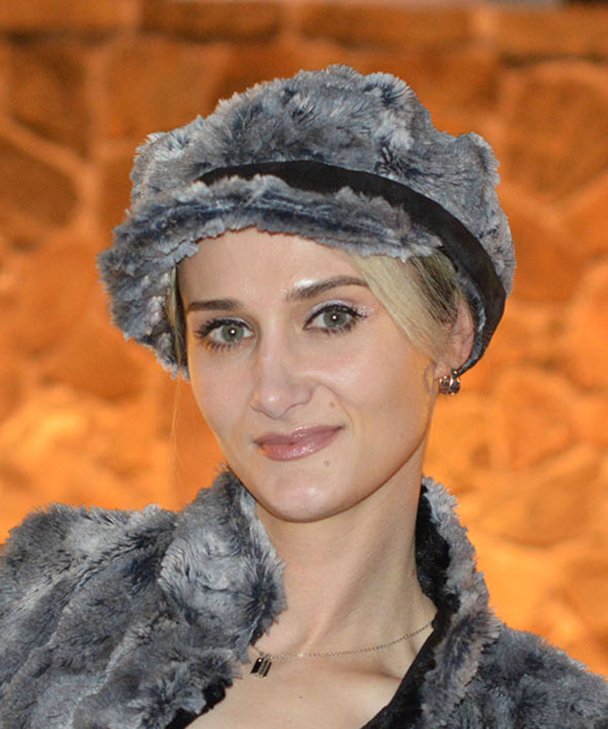 Model wearing Valerie Cap in Seattle Sky Faux Fur with faux suede against orange wall in Handmade in USA by Pandemonium Millinery