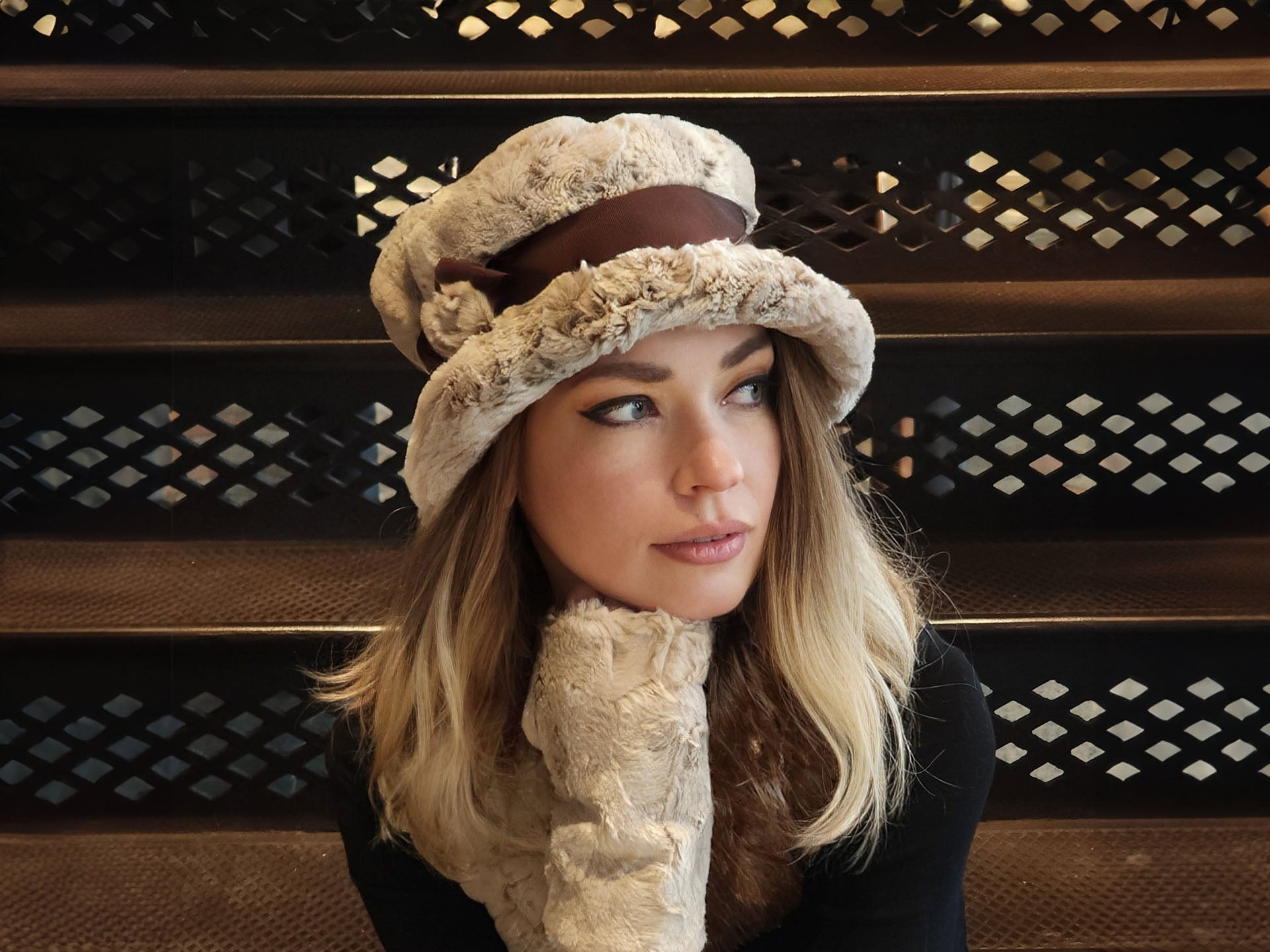 woman sitting on stairs wearing a cream and brown faux fur hat and glove set handmade in America by Pandemonium Seattle