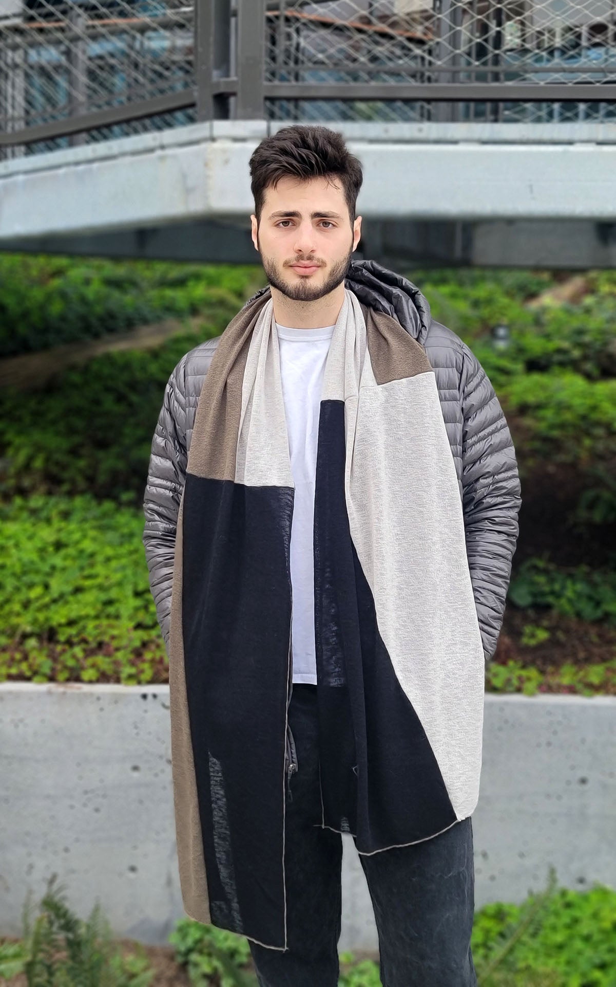 Man wearing the Upcycled Motley Scarf in the large pattern, and colors are Mezcal, Sandstone and Scorpion. Handmade by Pandemonium Seattle.