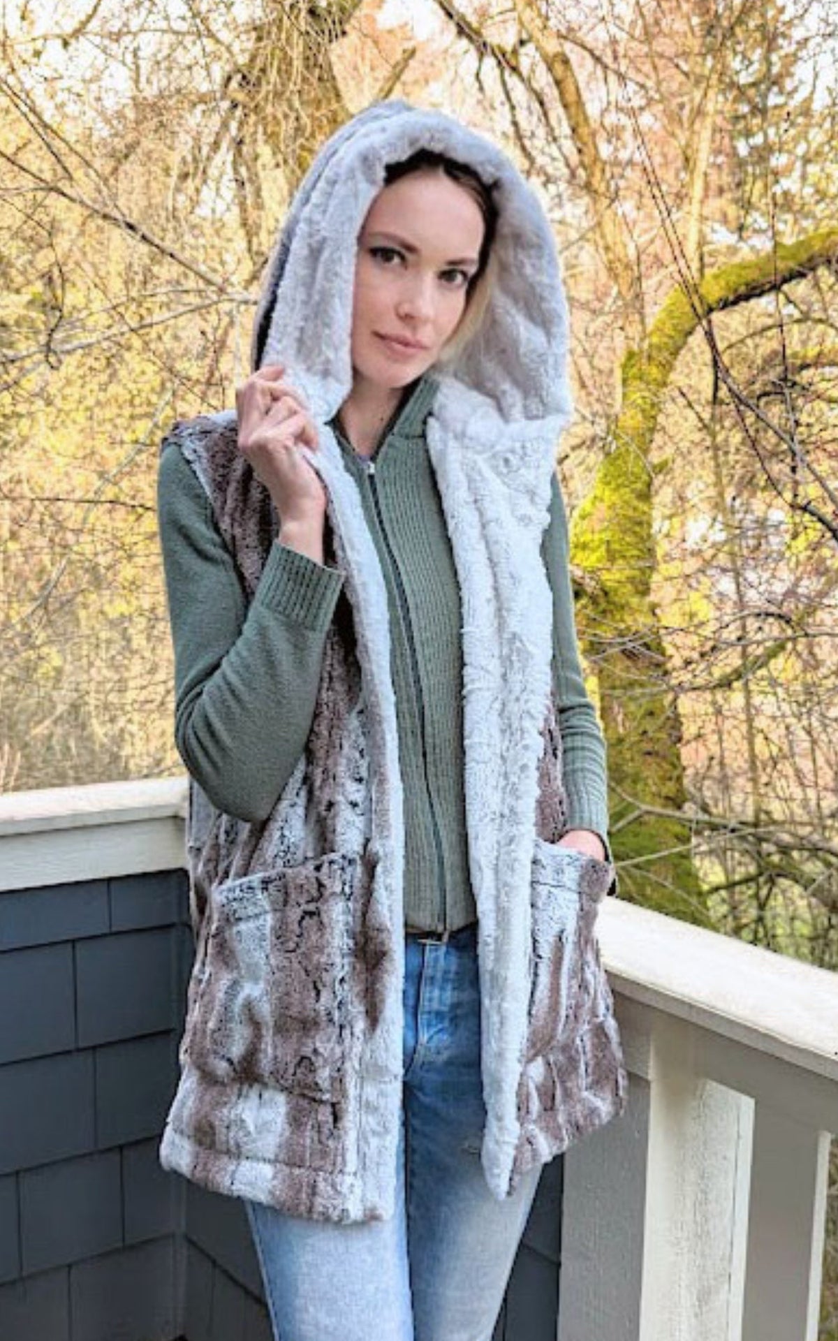 Woman wearing the Oversized Hooded Vest in Birch faux fur with reverse color of Cuddly Ivory faux fur. Handmade by Pandemonium Seattle.