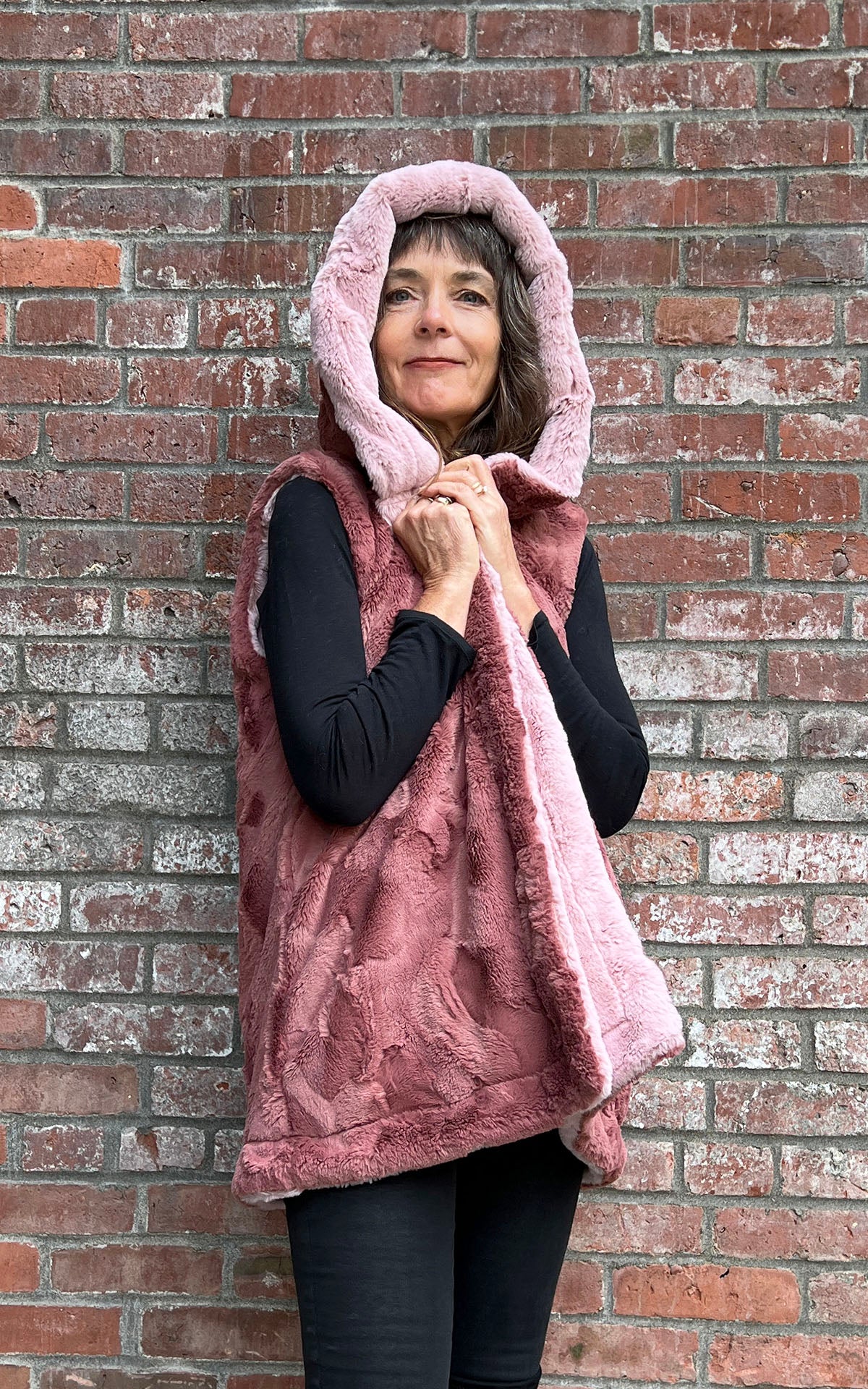 Woman in Oversized Hooded Vest in Frosted Cedar reversed to Copper River faux fur. Handmade in Pandemonium Seattle.