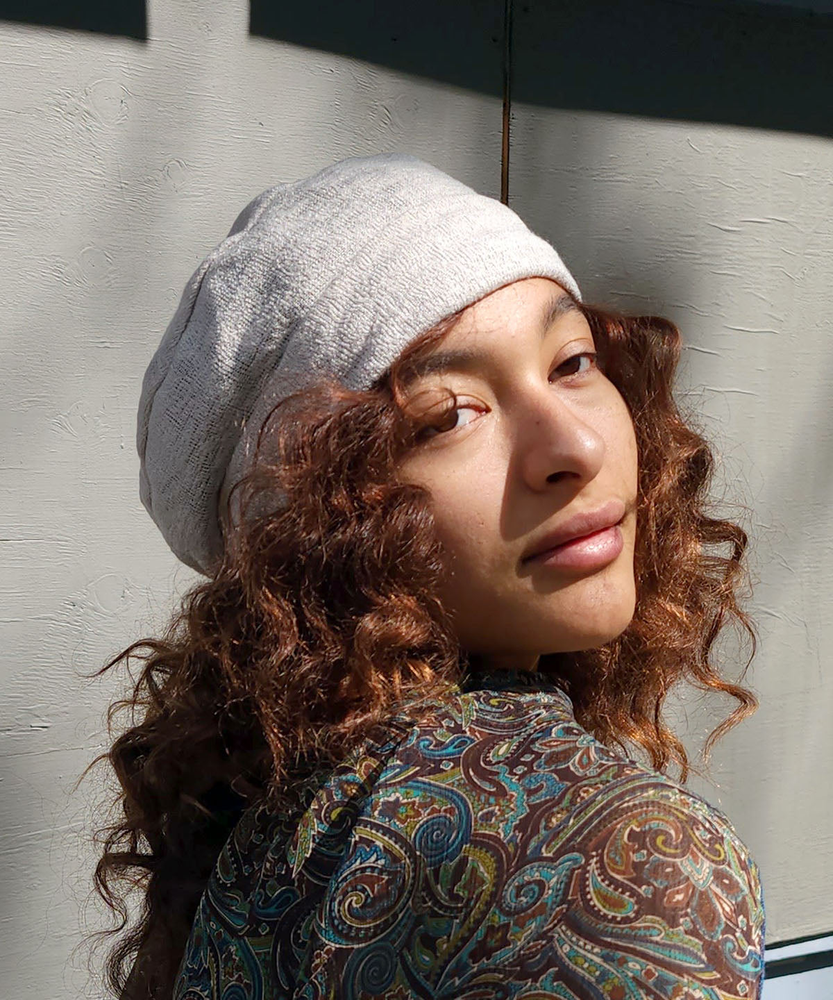 Close up view of woman wearing the Rowdie Hat in Mezcal. This Rowdie is made in soft crepe fabric. Handmade in Seattle, WA.