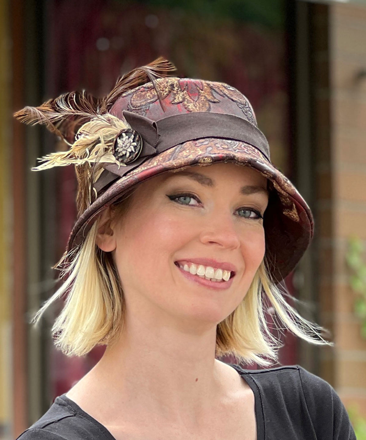 Woman wearing Samantha Bucket Hat | Renaissance In Ox Blood Upholstery | Feather and Button Brooch | Handmade in Seattle, WA USA by Pandemonium Millinery
