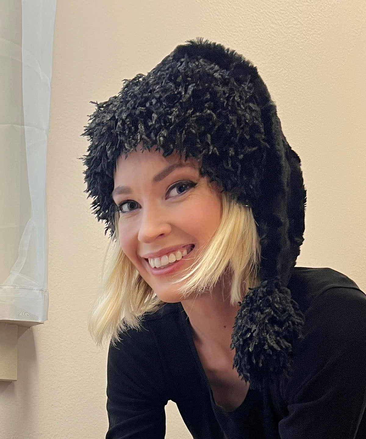 Headshot of Model wearing Santa Hat in Cuddly Black Luxury Faux Fur with Black Swan Cuff and Pom | Handmade in Seattle WA | Pandemonium Millinery