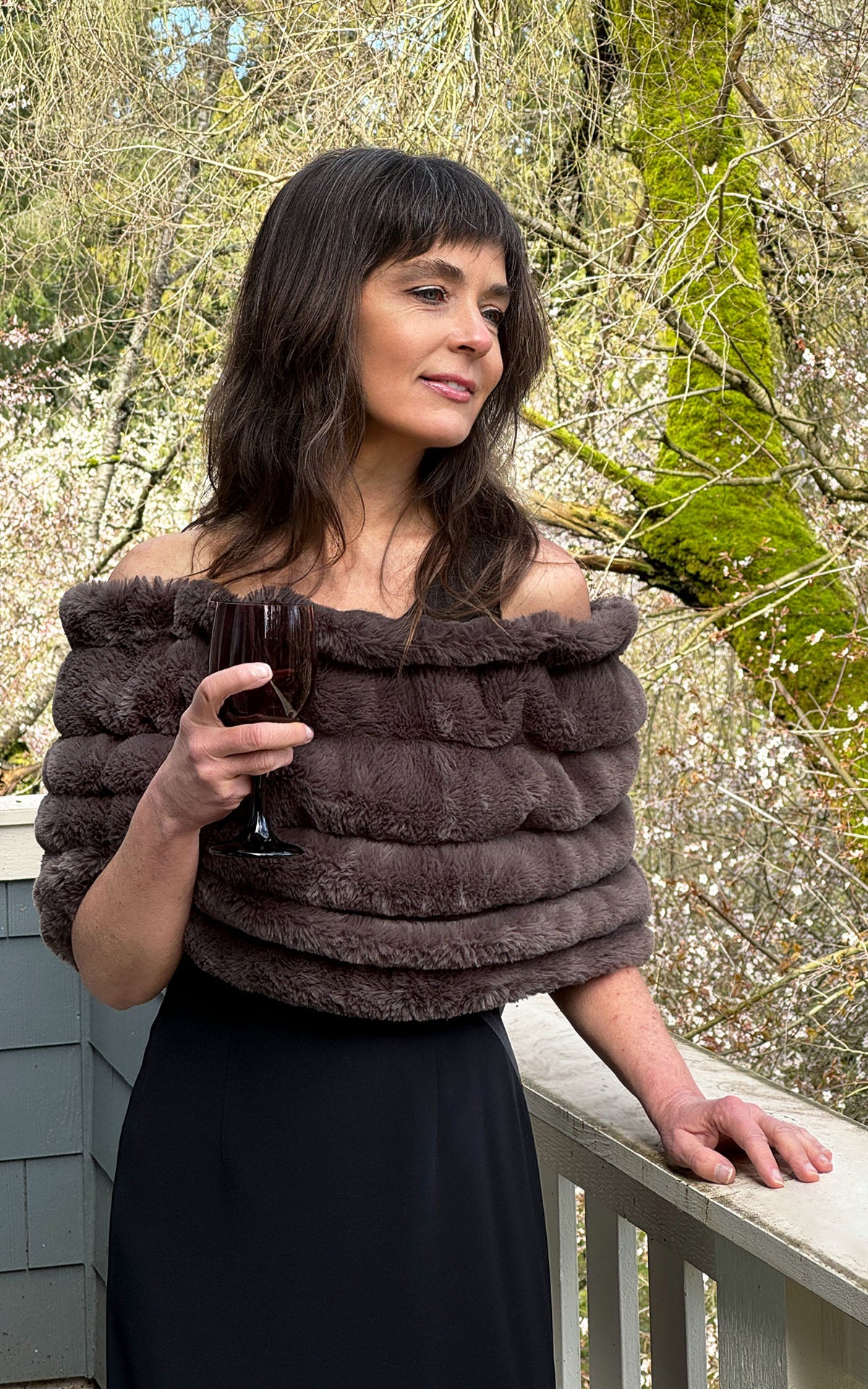 Model with wine glass wearing Royal Opulence Mink Gray Faux Fur Shoulder Wrap by Pandemonium Seattle.