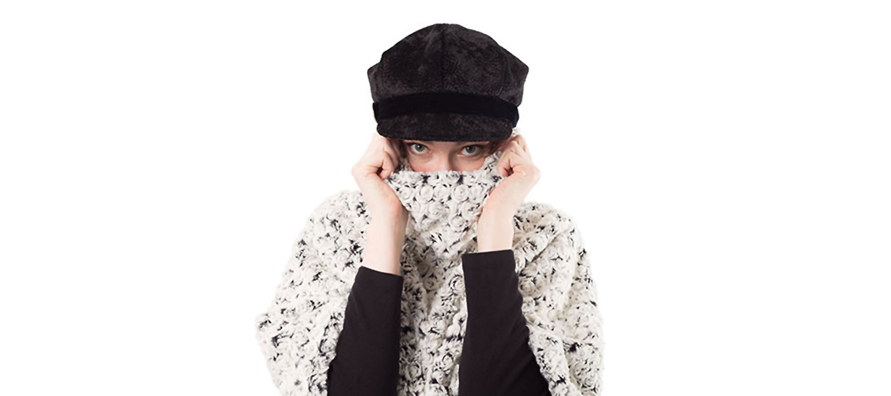 Woman Holding Collar of White Faux Fur Sweater over Face in Black Cap