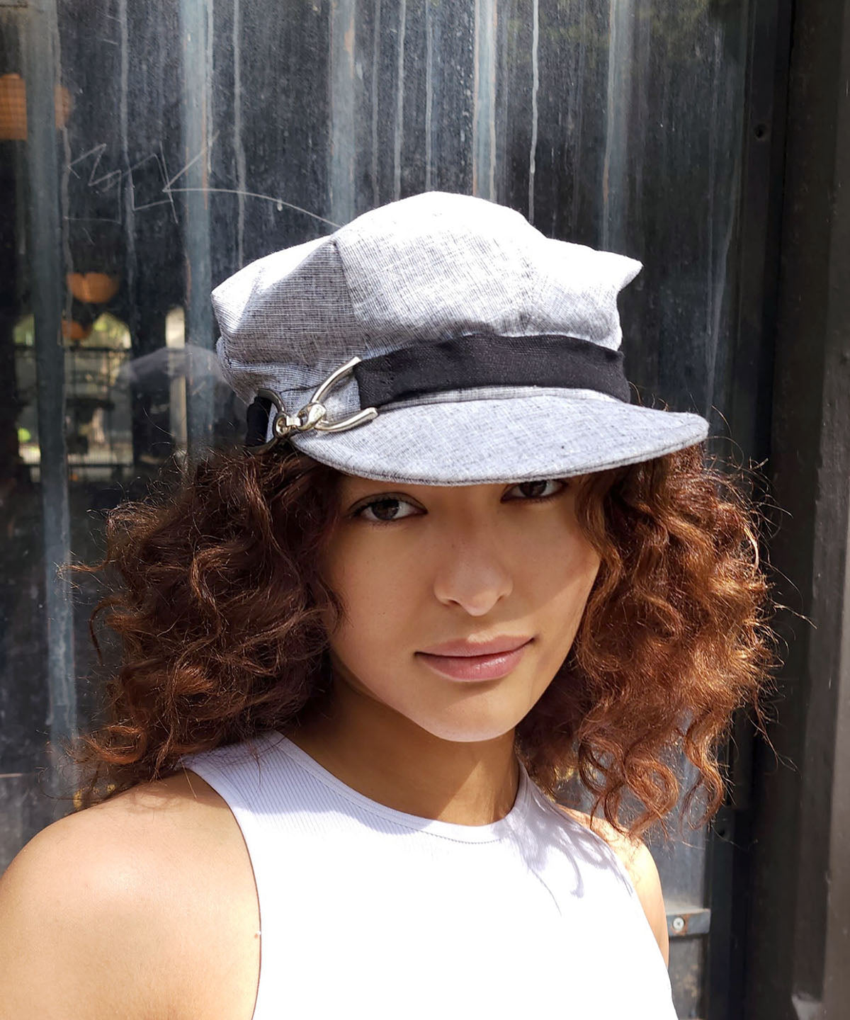 Woman wearing Valerie Cap in Metallic Silver Linen with Black Linen Band | Nickel Buckle Trim | Handmade by Pandemonium Millinery | Seattle WA USA