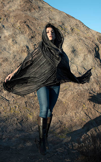 Model is wearing the Badlands Cloak in Reflections in Midnight, with hood up. By Leigh Young Collection handmade in Seattle WA