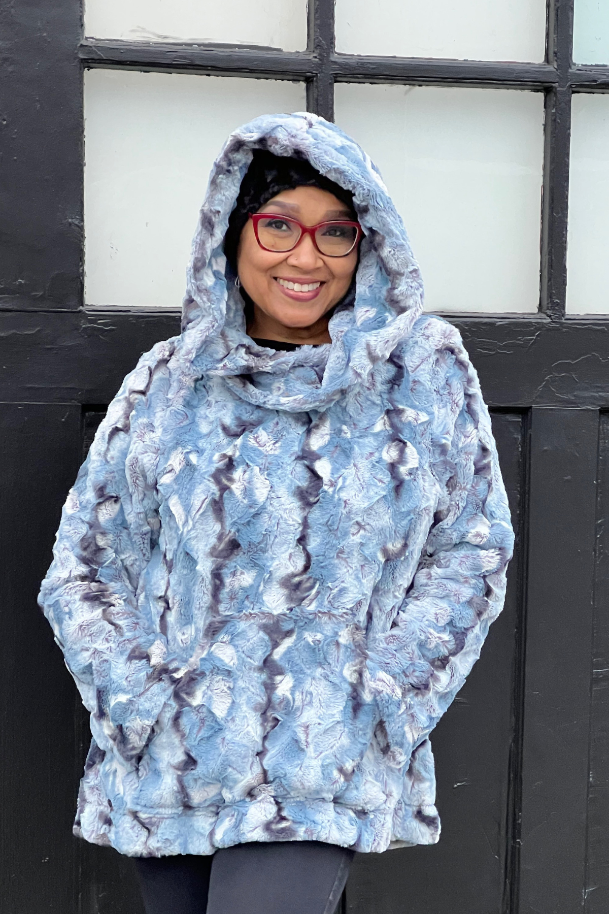 Woman wearing a Hooded Lounger in Rainier Sky, with the hood up. Handmade by Pandemonium Millinery in Seattle, WA, USA.