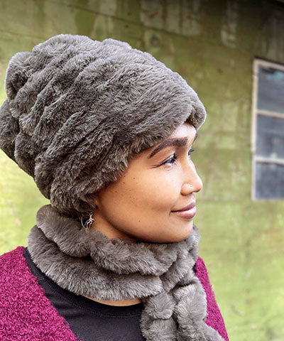 Woman in profile wearing the Faux Fur Beanie Hat in Mink Gray. The fabric is from the Royal Opulence Faux Furs. Pandemonium is located in Seattle, WA.