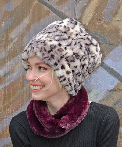 Woman in profile to model the Handmade Beanie Faux Fur Hat in Royal Opulence in Snow Leopard (Black and White Leopard Print).