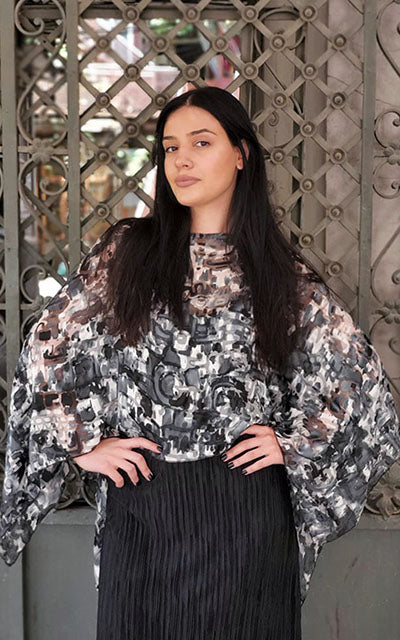 Woman wearing the Garden Path Poncho in Sand Dollar. Made in Seattle, WA, USA by Pandemonium Seattle.