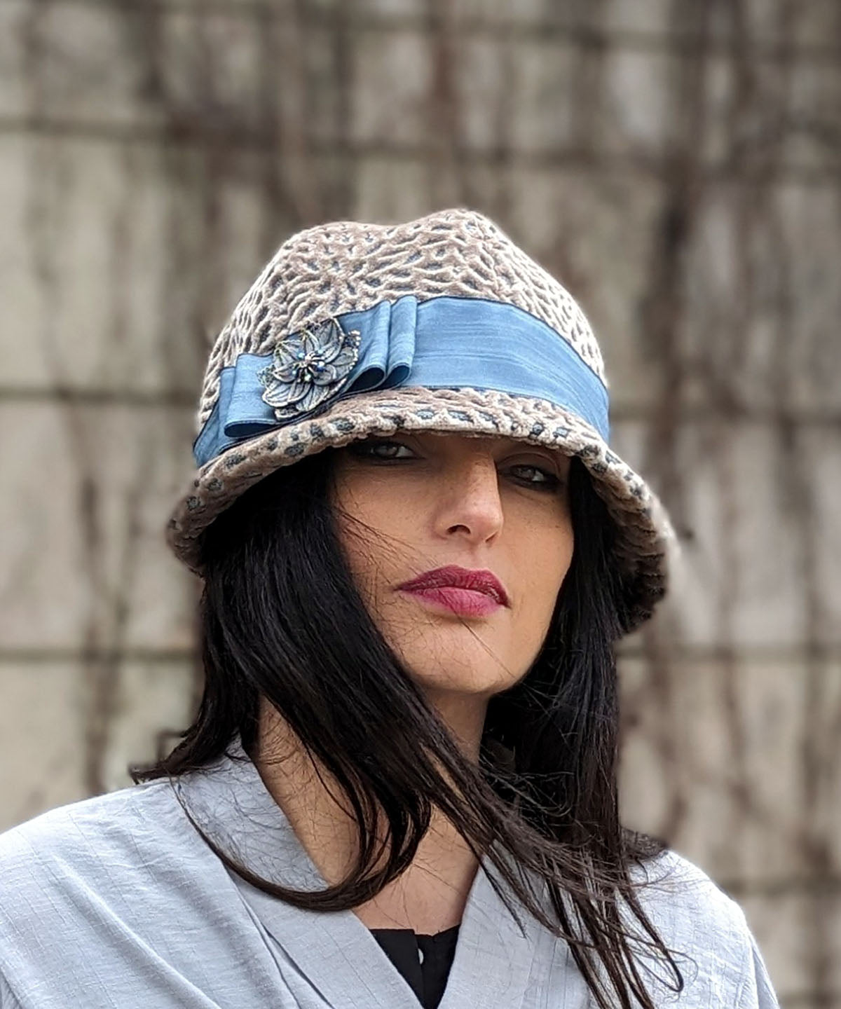  Model wearing  Grace Cloche Hat in Rossini Upholstery Fabric with Band and Bow Trim in French Blue Moiré Taffeta featuring a Steampunk Floral Brooch | By Pandemonium Millinery | Handmade in Seattle WA USA