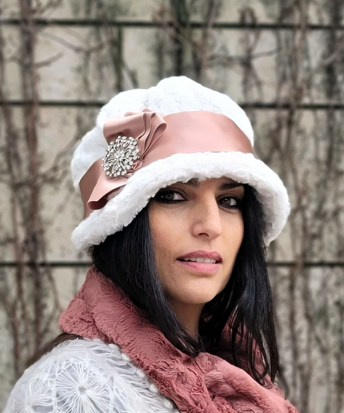 Close up of Model wearing Grace 1920s Cloche Style Hat  in Cuddly Faux Fur Ivory featuring Apricot Satin and Three Fold Bow with Rhinestone Brooch | Handmade By Pandemonium Seattle | Seattle WA USA