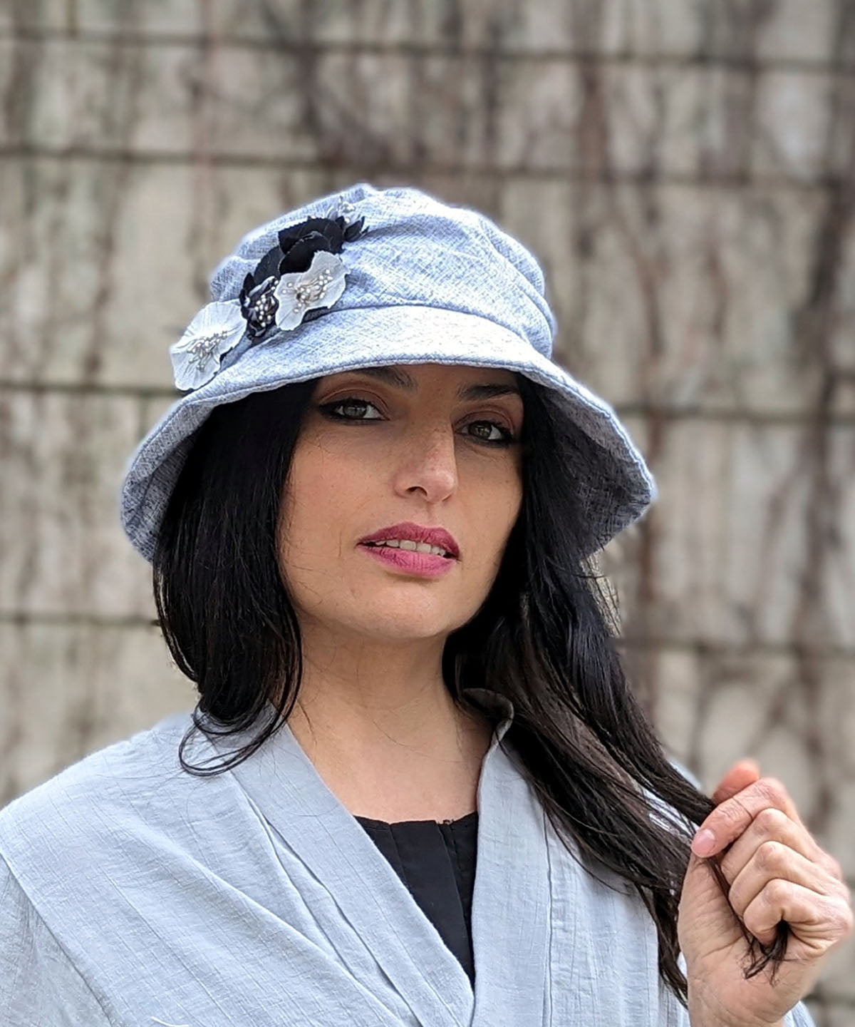 Modeling wearing Krystyne Hat Linen in Metallic Silver with Custom Black And White Flowers by Pandemonium Millinery. Handmade in Seattle WA USA.