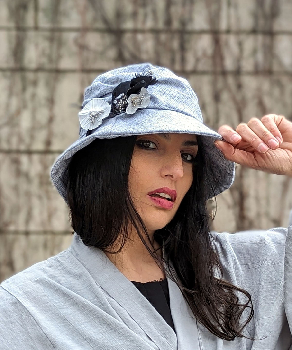 Modeling wearing Krystyne Hat Linen in Metallic Silver with Custom Black And White Flowers by Pandemonium Millinery. Handmade in Seattle WA USA.